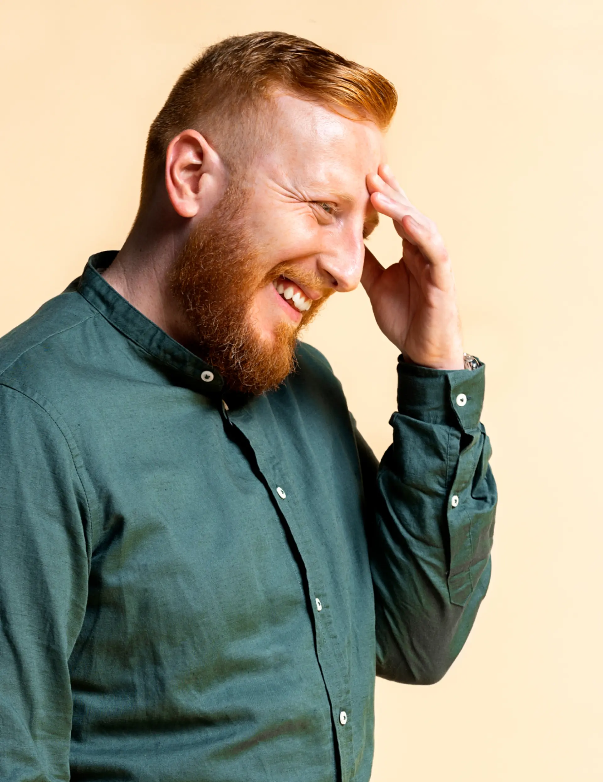 Man with hand on head, thinking, and smiling. 