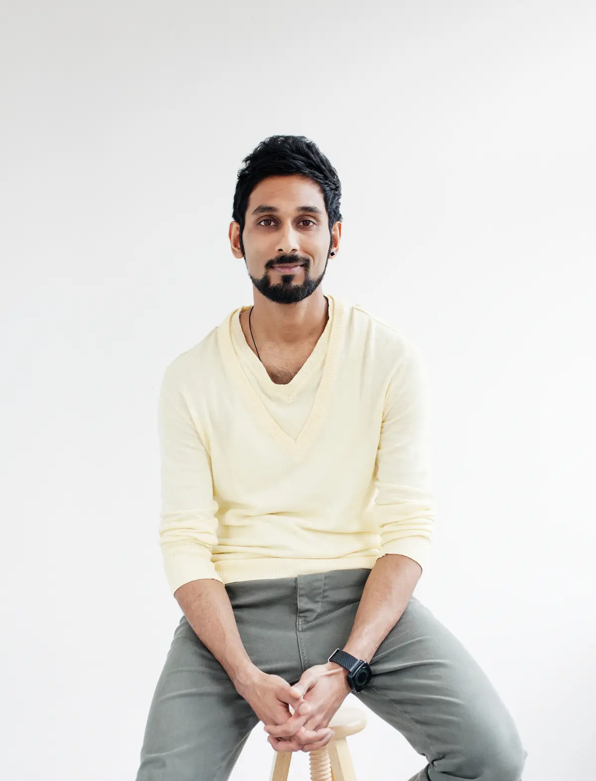Man sitting on stool in office. 